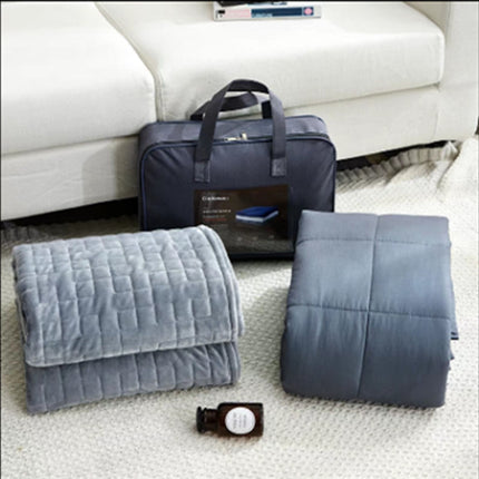 Folded gray blanket and carrying bag on a white surface